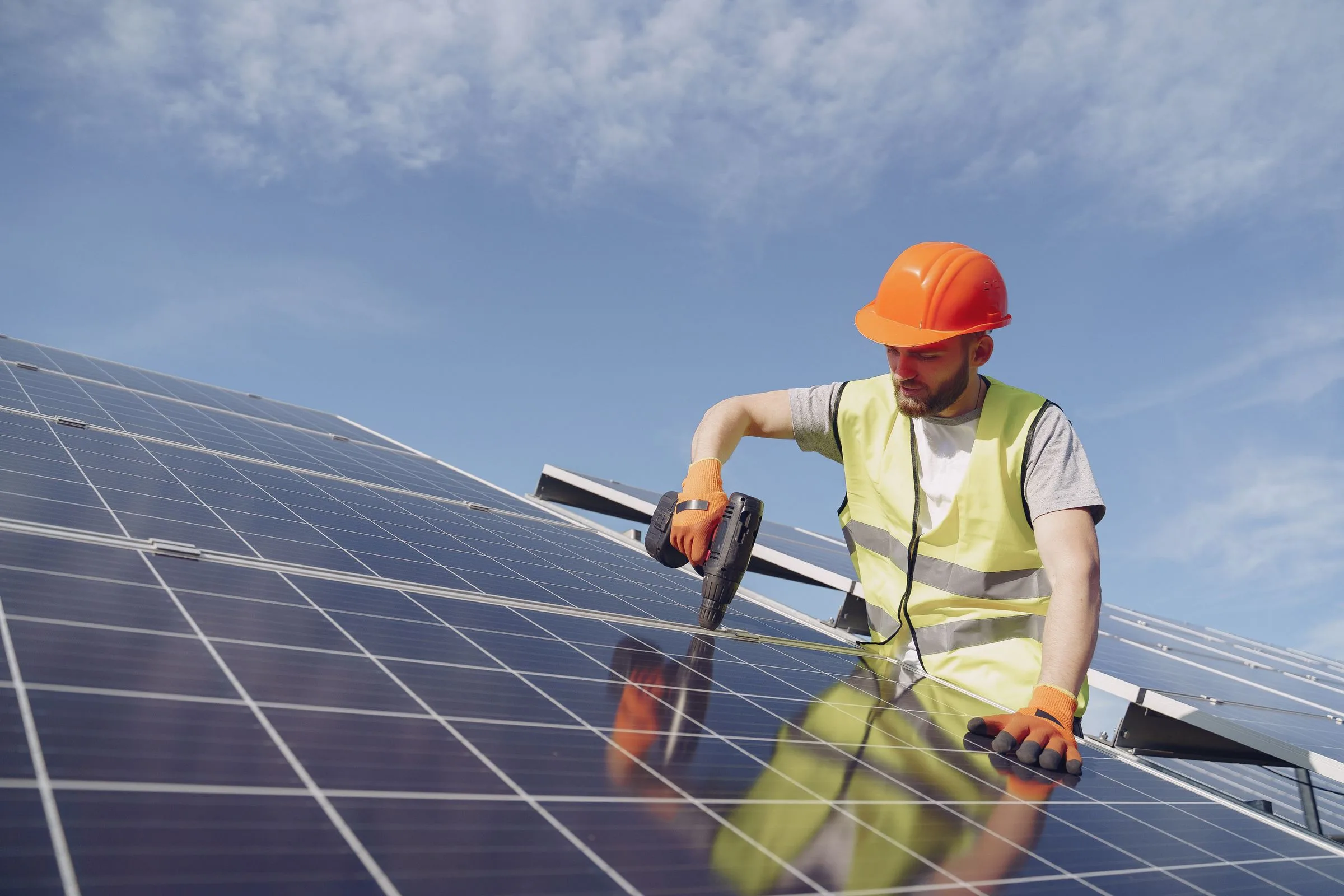 Elektriker i sikkerhedsudstyr monterer solceller